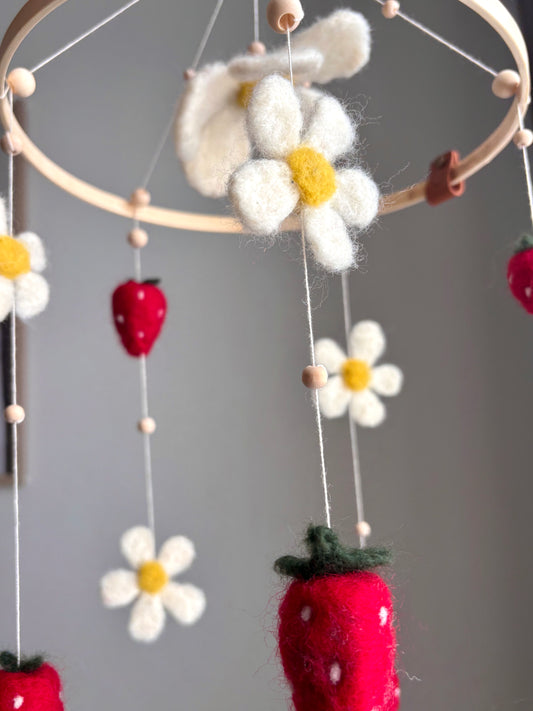 Röda handgjorda jordgubbar tillsammans med vita och gula prästkragar.