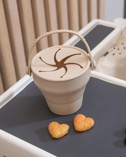 Denna snackbox med lock och handtag är perfekt för den lilla att plocka själv ur. Spiralöppningen gör att snackset stannar kvar i boxen samtidigt som en liten hand kan hämta upp. Kan vecklas ut och bli från 3,5 cm till 8 cm hög. Perfekt för picknicken eller i bilen. Från JFR
