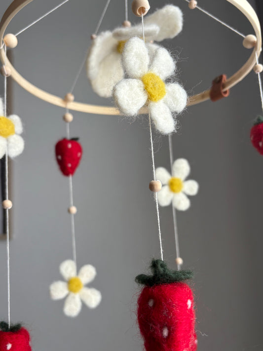 Babymobil i tovad ull med blomster och jordgubbar som stimulerar barnets syn