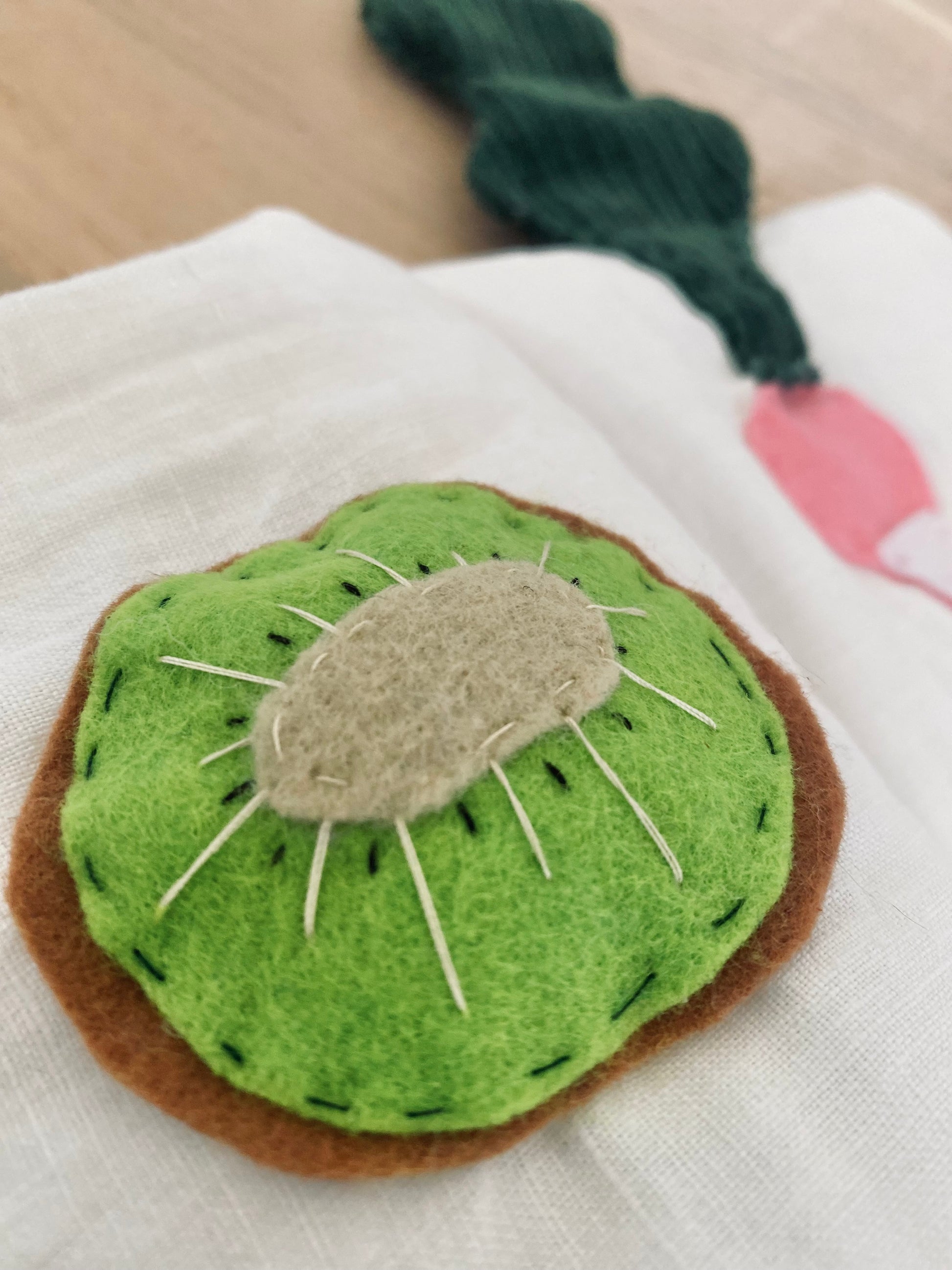 Handgjord tygbok med frukt i filt med motiv av kiwi, rädisa, äpple, päron och avokado