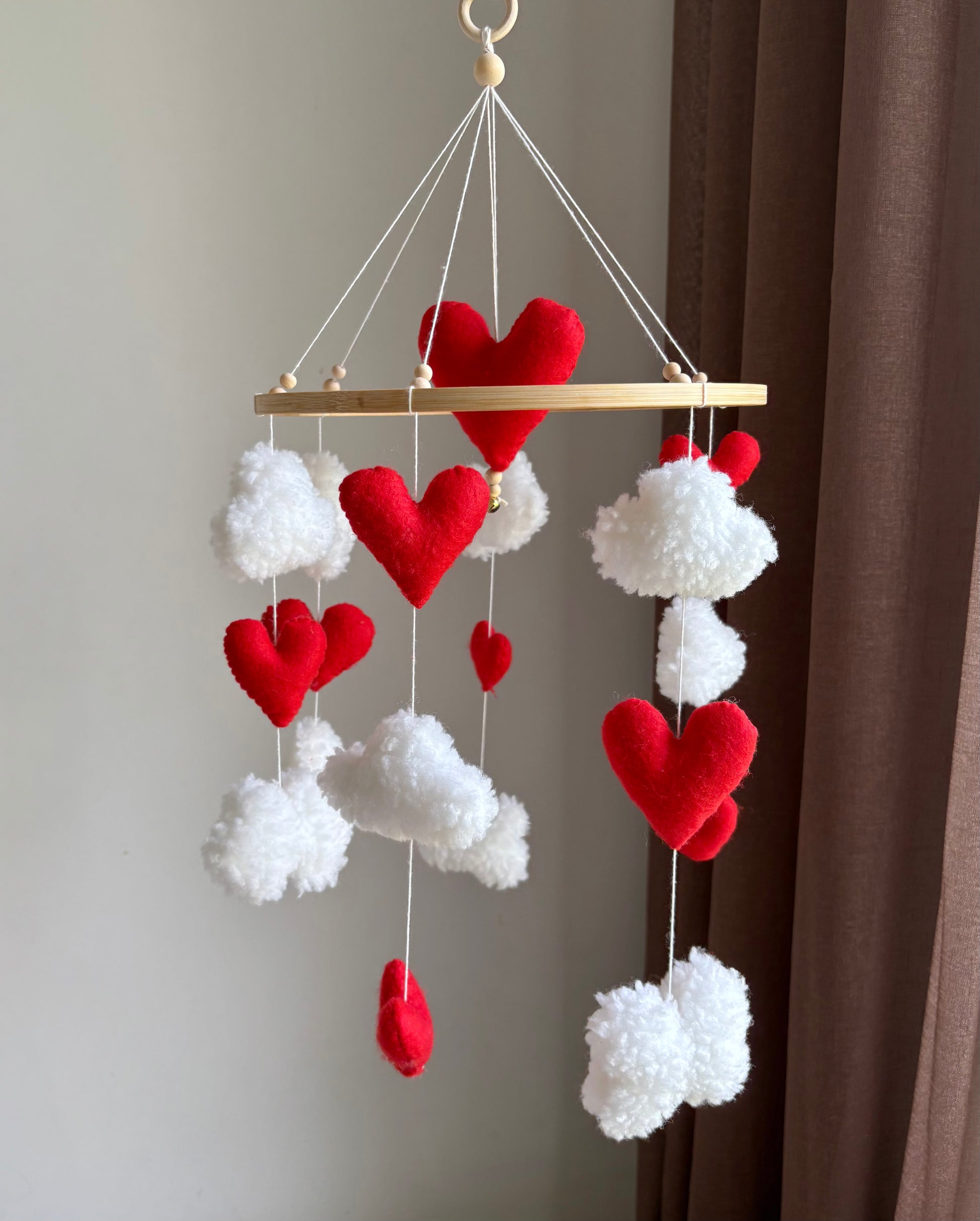 Handgjord babymobil i filt – röda hjärtan bland vita moln