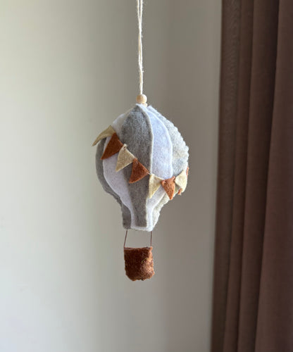 Handgjort barnvagnshänge i filt – luftballong med färgglada vimplar