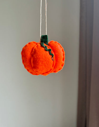 Handgjort barnvagnshänge i filt formad som orange pumpa