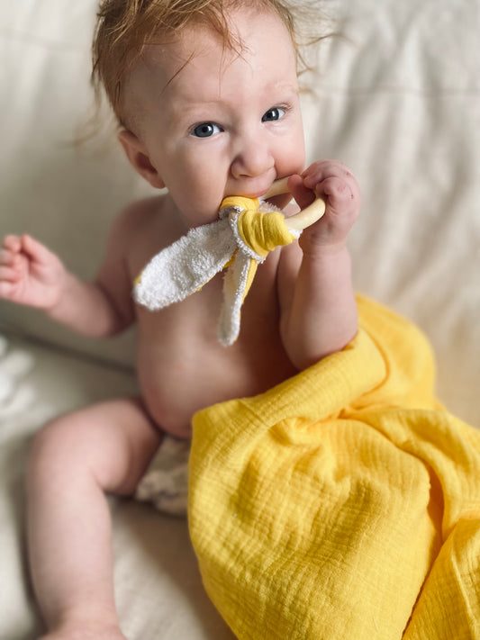 Leksak för bebis att bita på för teething och kliande tandkött. Gul bitring med kaninöron i muslin och frotté 