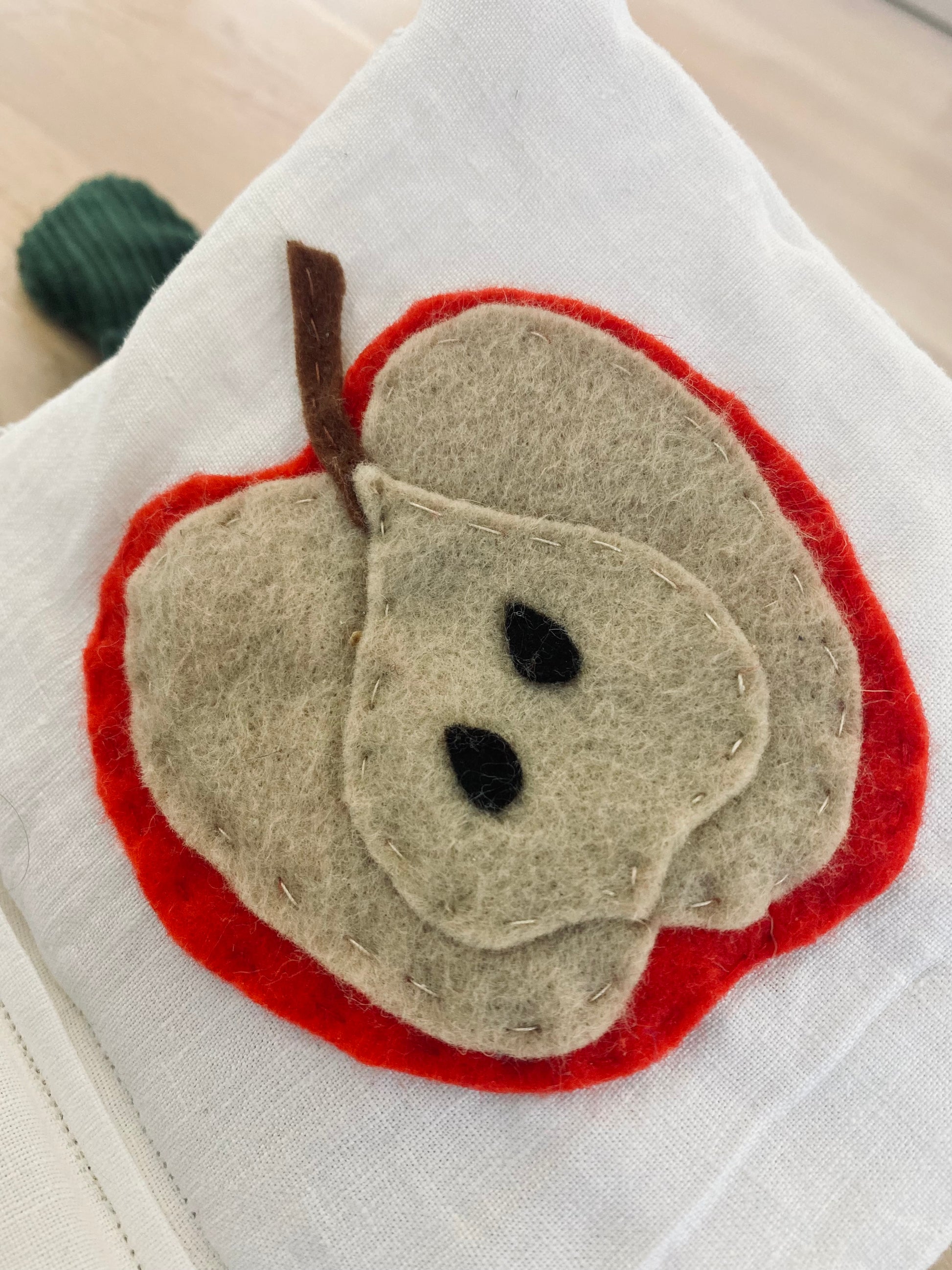 handgjord prasselbok med frukter och grönsaker i filt med motiv av ett rött äpple i  tyg