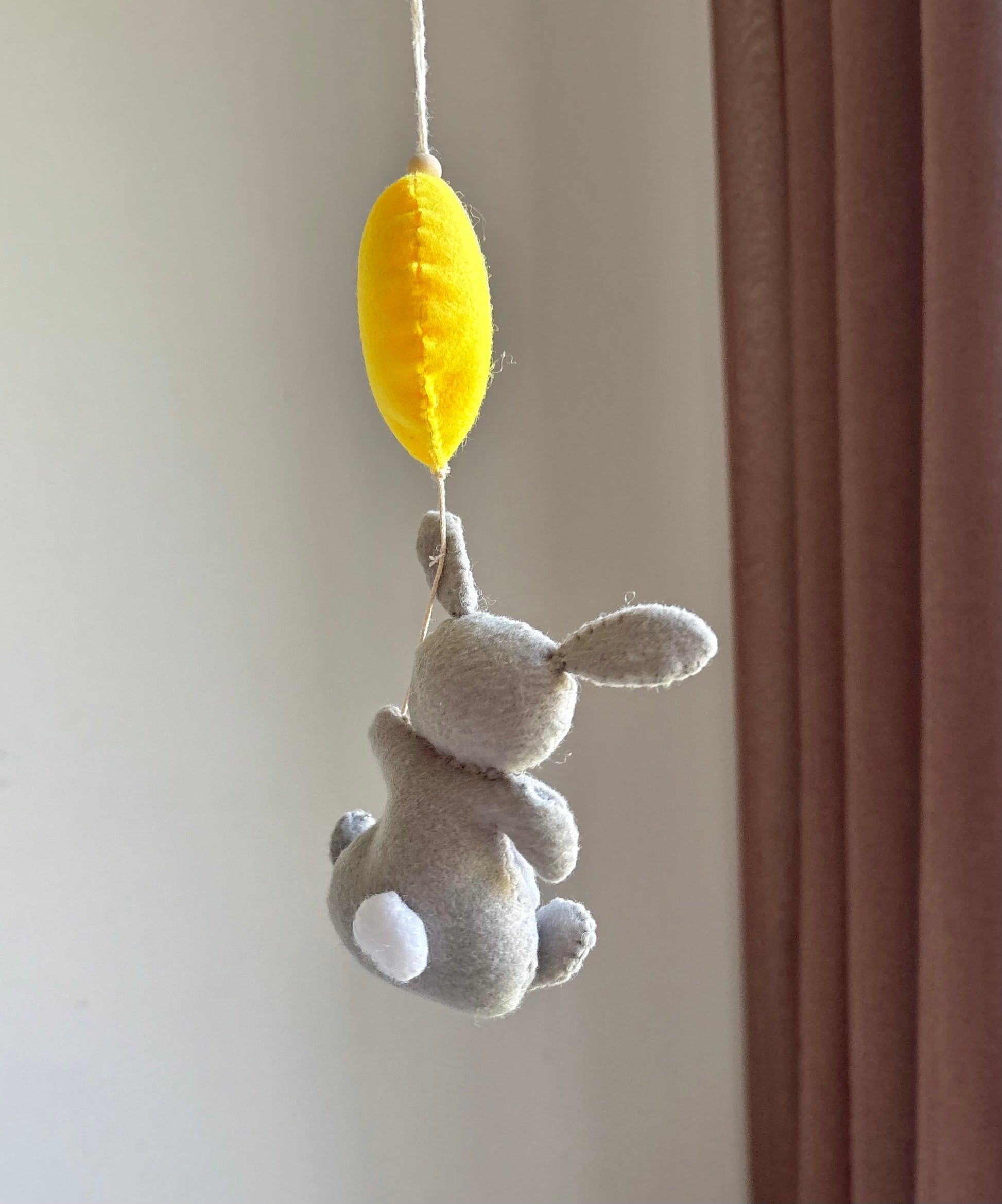 Svenskt handgjort barnvagnshänge – kanin med gul ballong