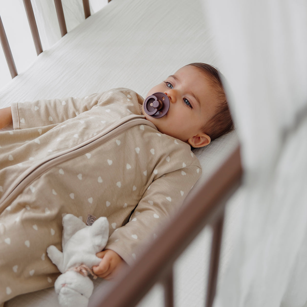 Beige sovpåse med ärmar för baby som ger trygg och jämn sömn