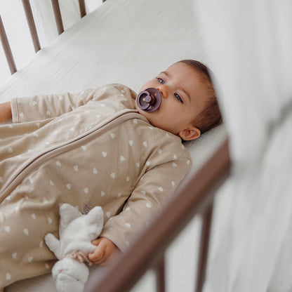 Beige sovpåse med ärmar för baby som ger trygg och jämn sömn
